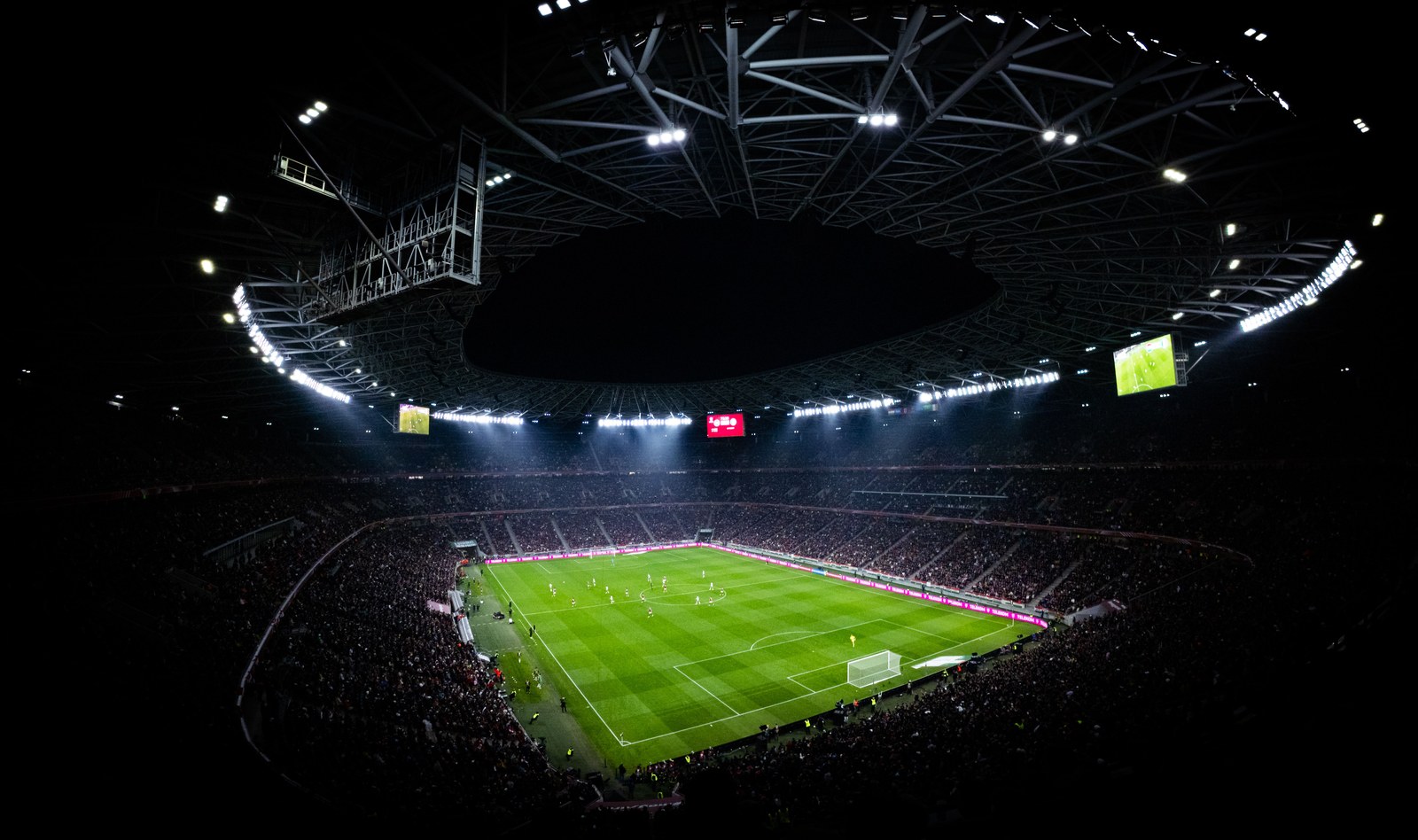SimianX AI Aerial view of a floodlit football stadium at night SimianX AI Aerial view of a floodlit football stadium at night
