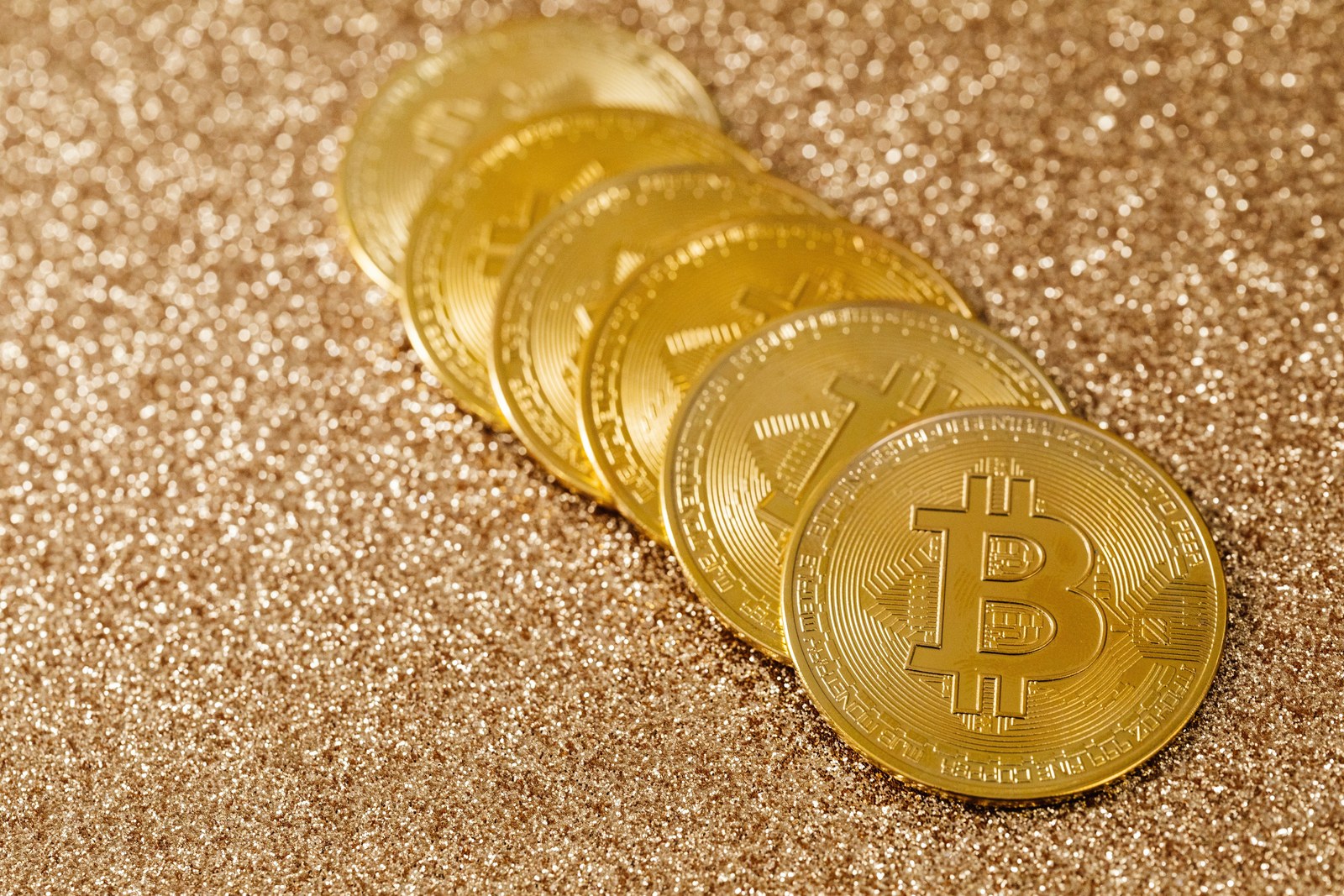 SimianX AI Stack of gold Bitcoin coins on a shimmering background SimianX AI Stack of gold Bitcoin coins on a shimmering background