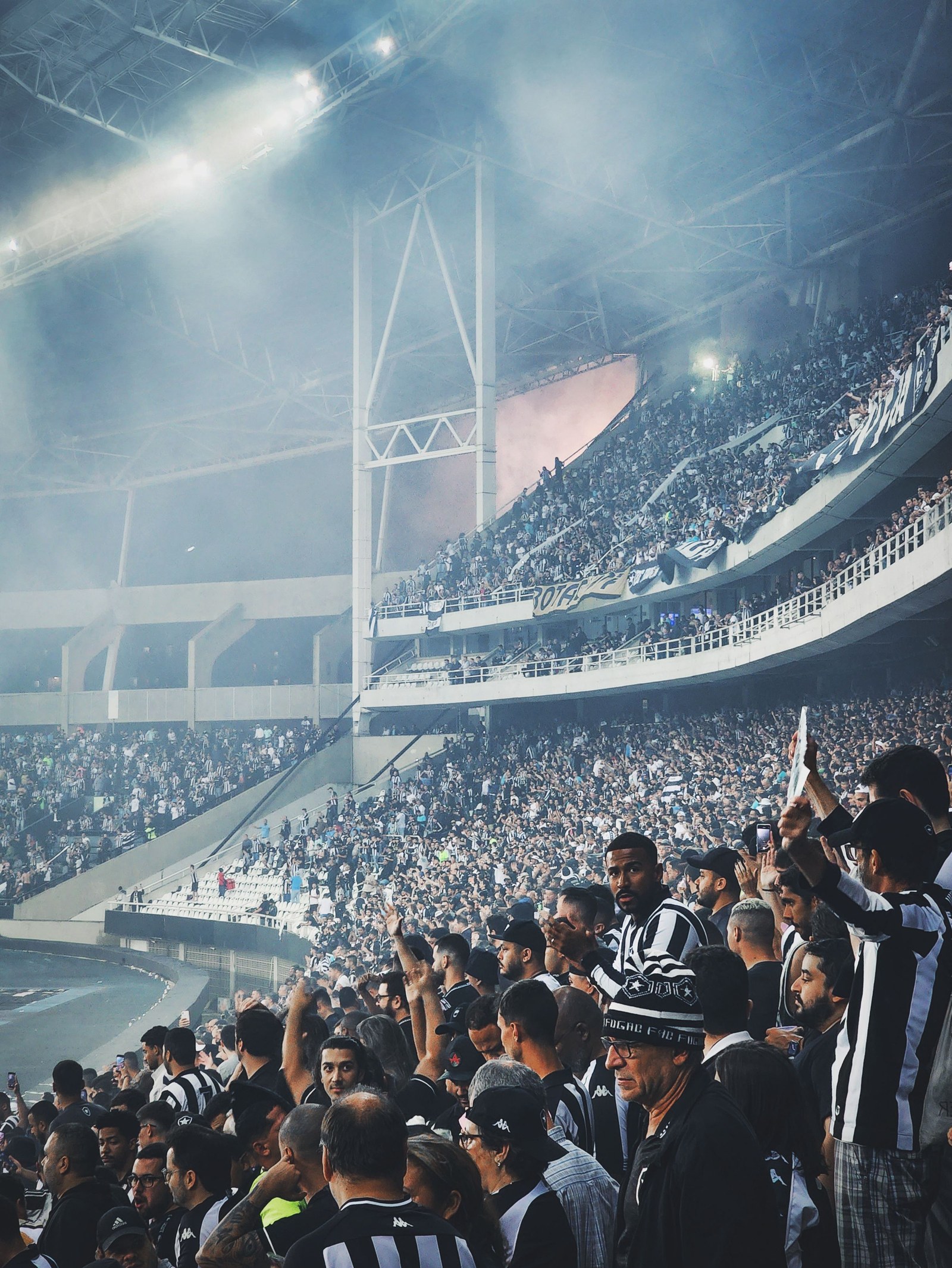 SimianX AI Soccer fans packed into a stadium with scarves and flags SimianX AI Soccer fans packed into a stadium with scarves and flags